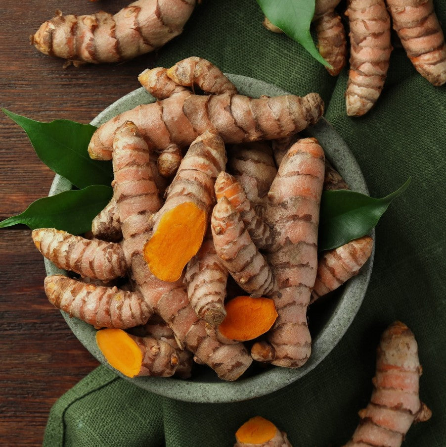 Gurkmeja i en skål med blader, känd för sina antioxidanta och anti-inflammatoriska egenskaper.