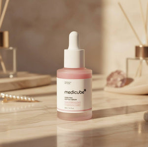 Medicube PDRN Pink Peptide Serum 30ml i en elegant flaska på ett marmorbord.
