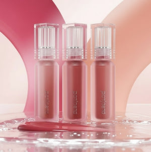 Tre läpptintsflaskor i nude-beige toner med genomskinliga skruvkapsyler