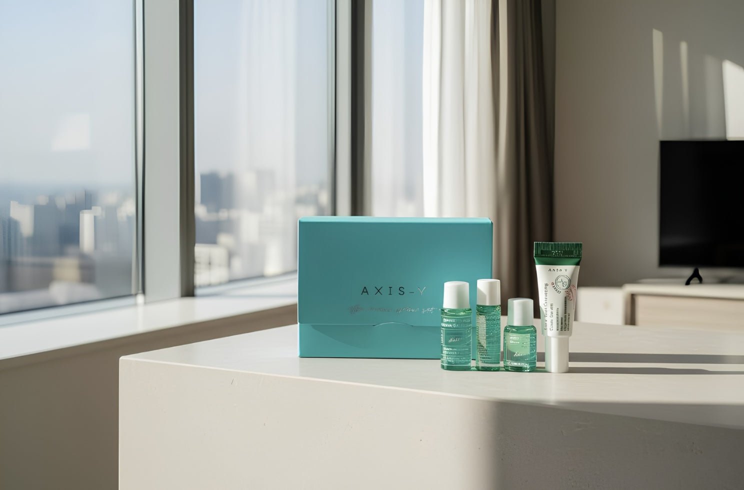 Axis-Y Mini Glow Set med fyra produkter för hudvård placerad på ett bord i soligt rum.