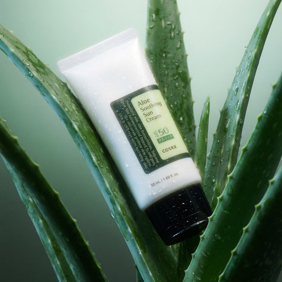 Solkräm i vit tub från COSRX med aloeetikett och SPF 50, svart lock