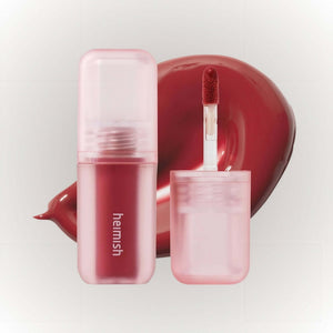 Heimish Dailism Lip Gloss #04 Sheer Red med applikator och röd läppfärg på en neutral bakgrund.